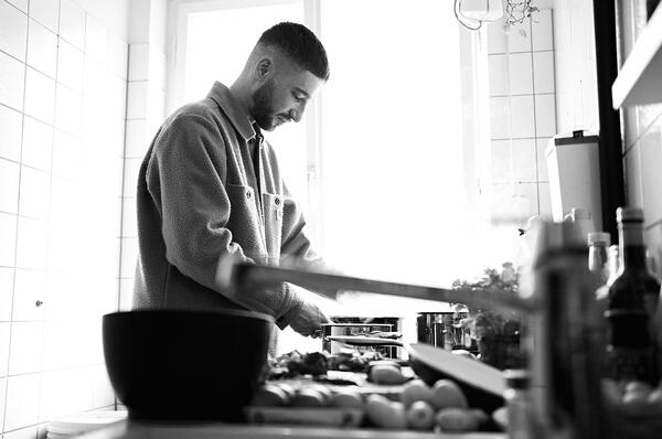 black and white photo of a man cooking