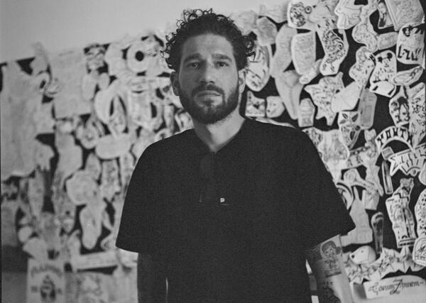 a man standing in front of a wall with sketches