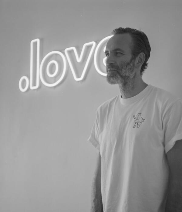 A man standing in front of a glowing neon sign.