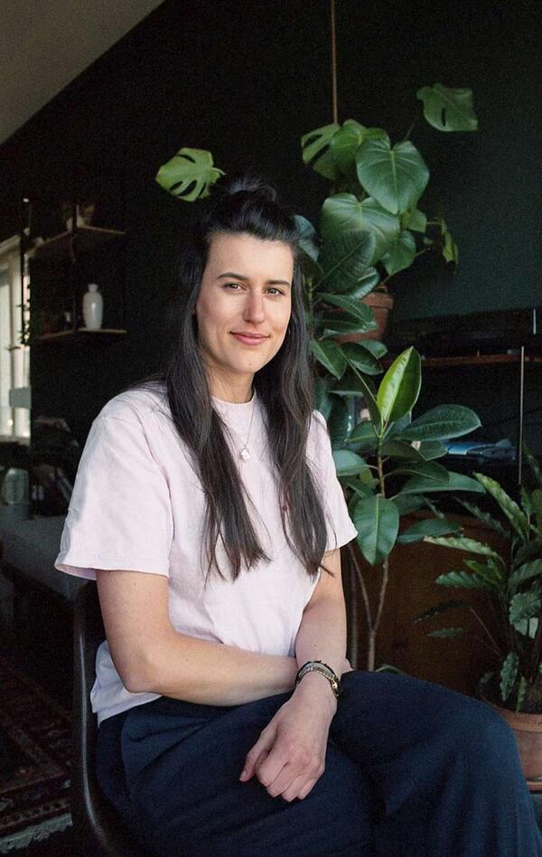 a woman sitting in front of plants